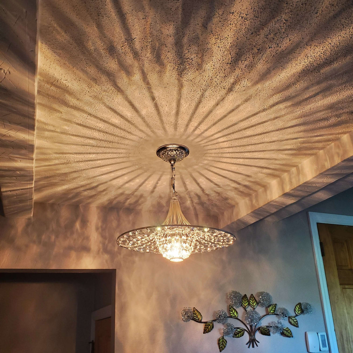 Elegant silver three light pendant casting intricate shadows on the ceiling, enhancing modern interior design.